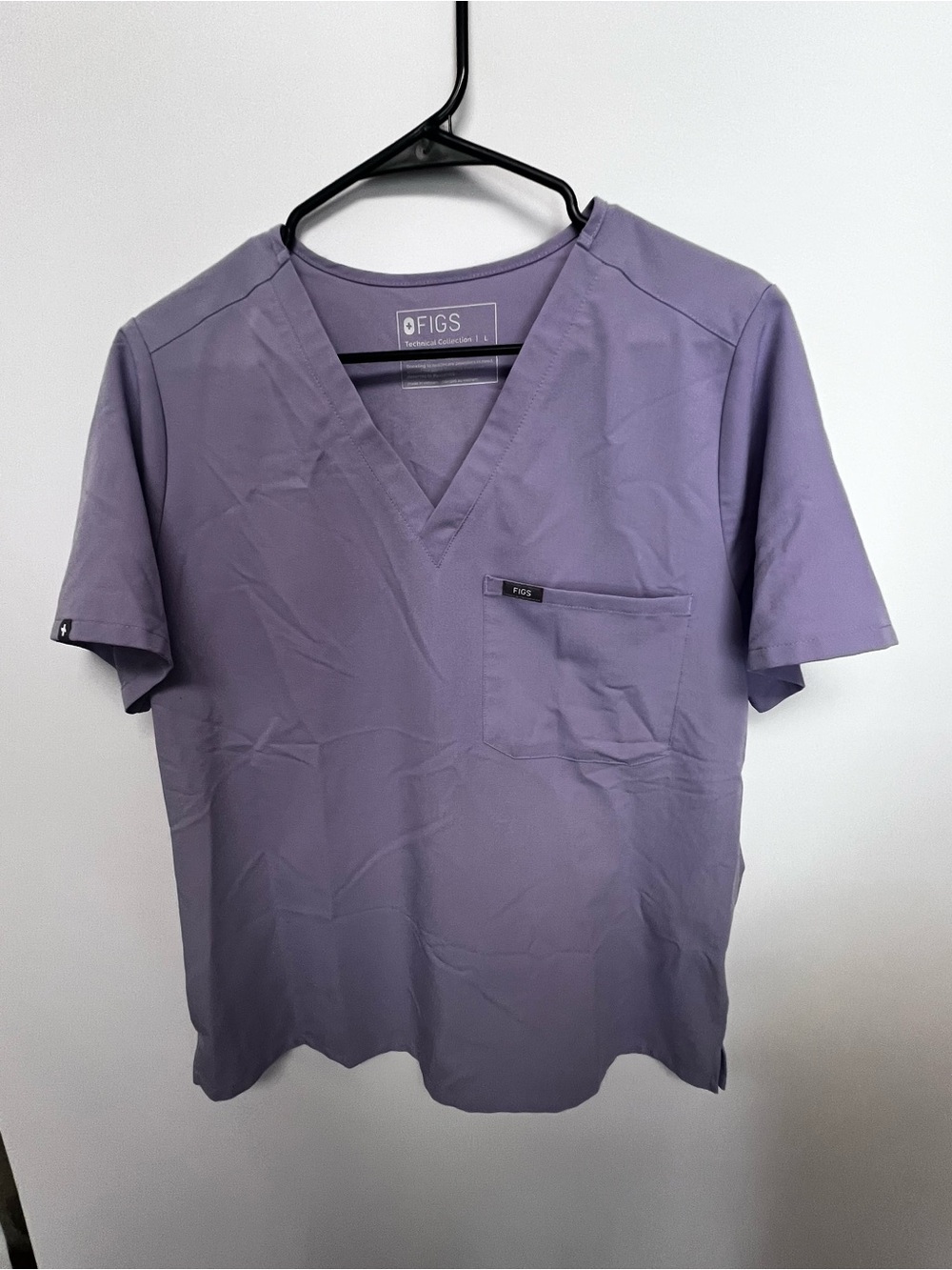 FIGS WOMEN V NECK SCRUB TOP IN LAVENDER. 
TECHNICAL SUPPORT 1 FRONT LEFT POCKET